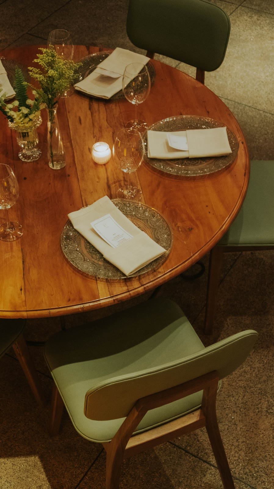 A candlelit dinner table with flowers and formal place settings.